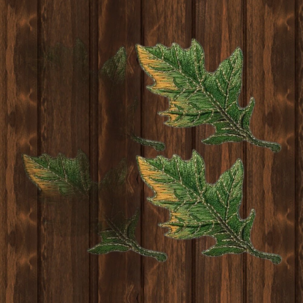 Detail showing two green leaf patches from the four-patch set on a wood background