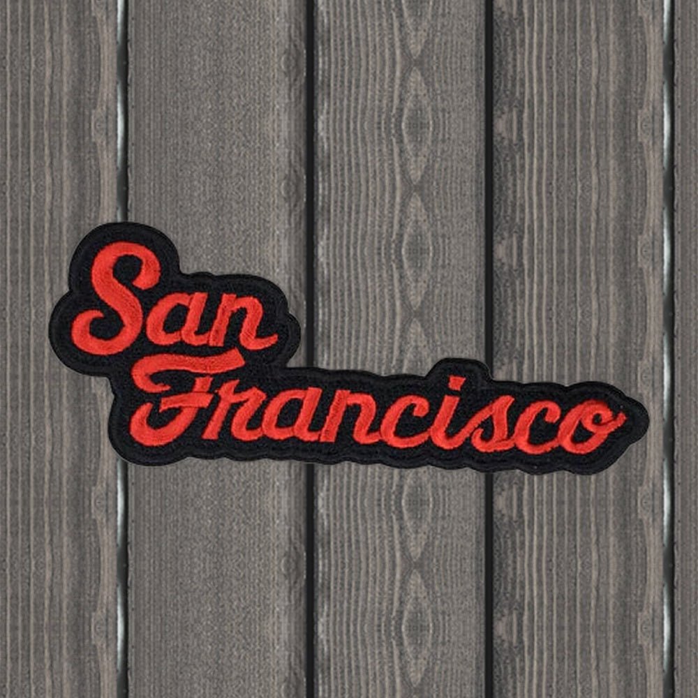 San Francisco red and black script embroidered patch, 4-5/8 inches wide, on a wood background