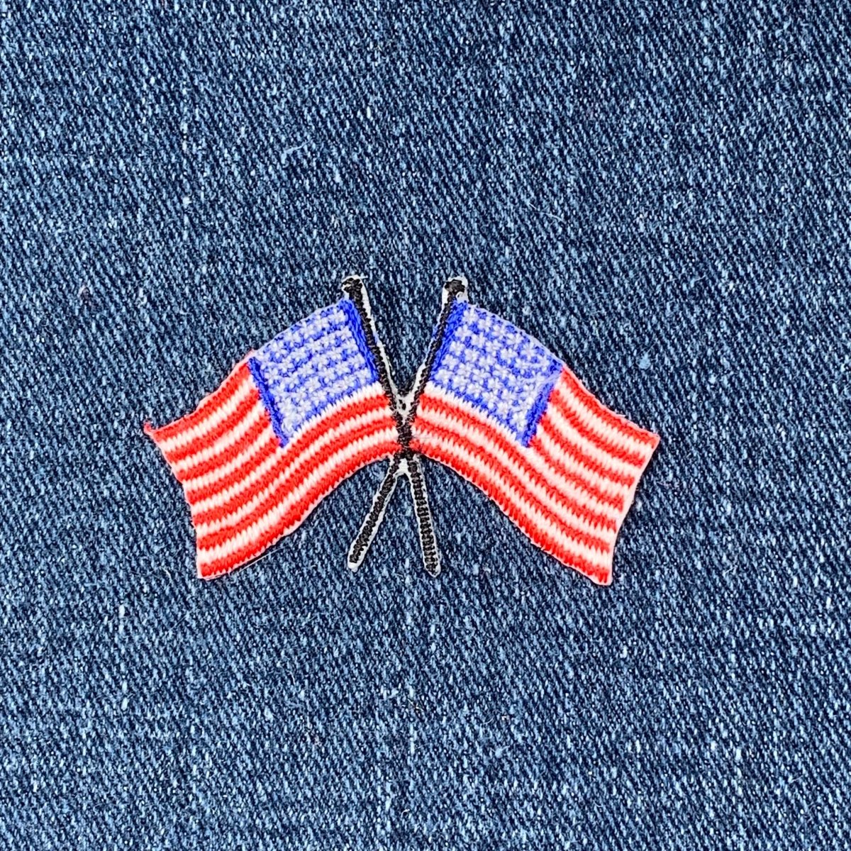 Two crossed American flag patch on a denim background