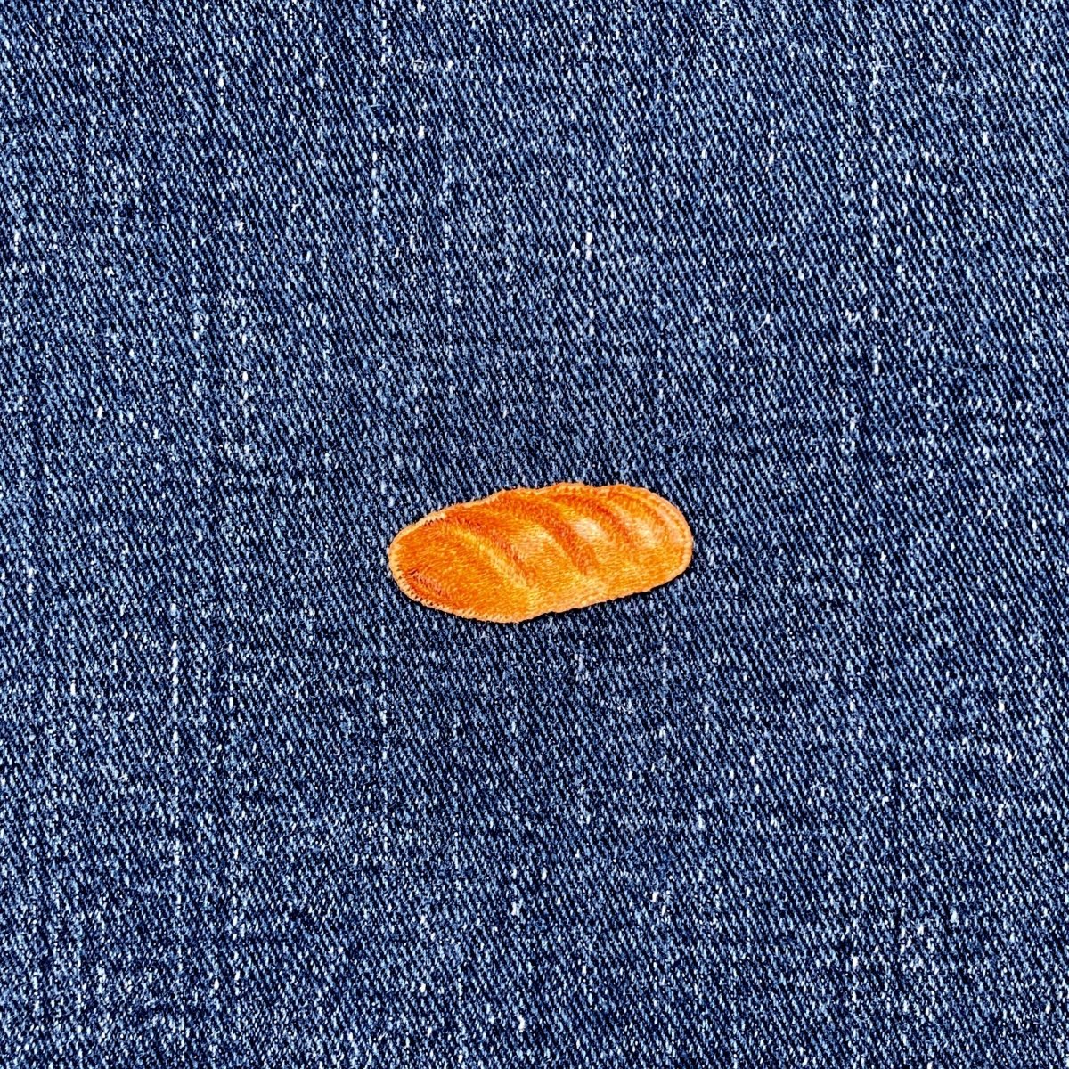 Small French bread patch on a blue denim fabric background