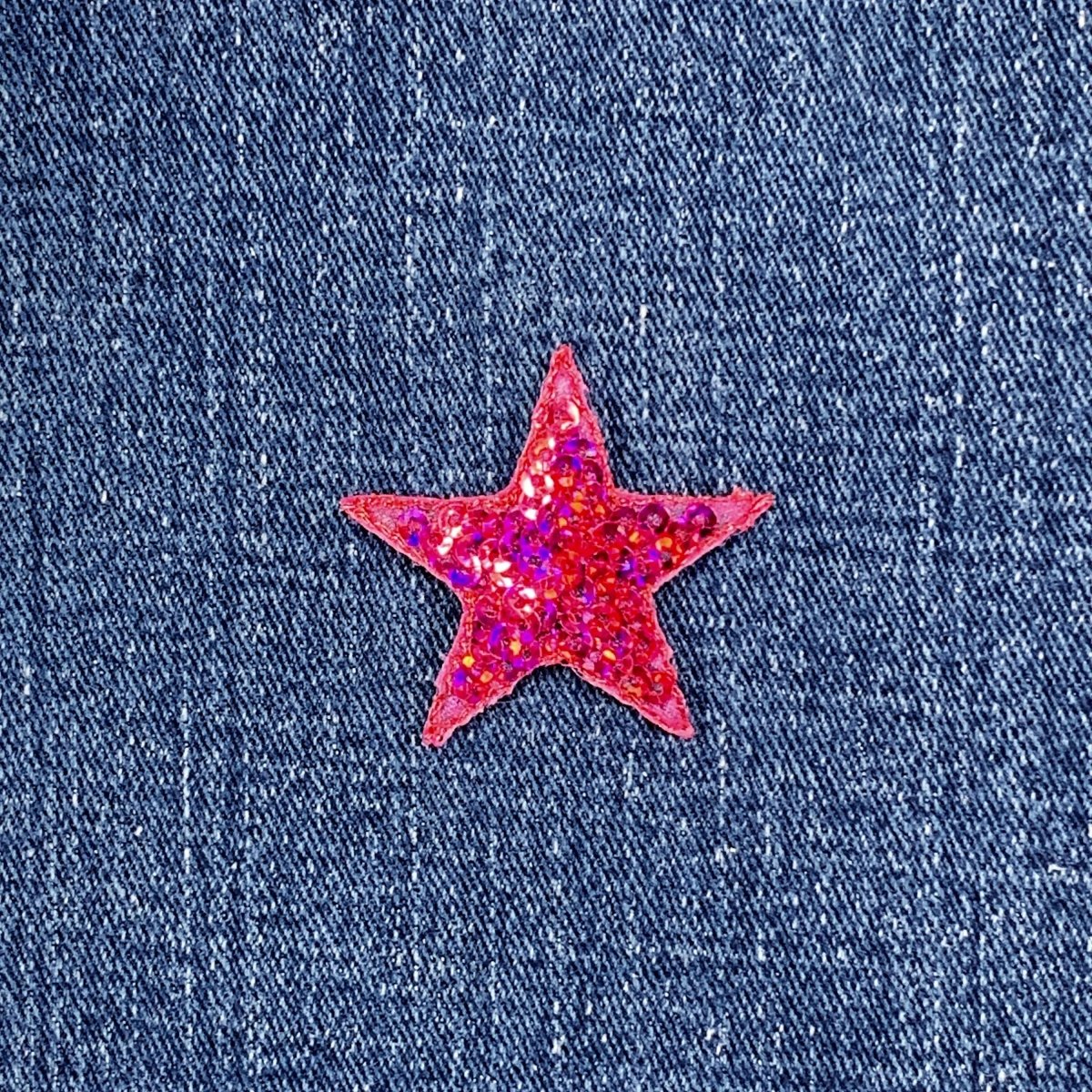 Pink sequin star patch on blue denim fabric