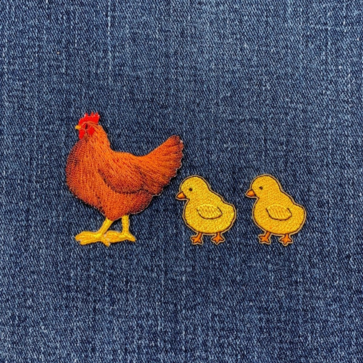 Embroidered patch of a chicken hen and two chicks on denim fabric