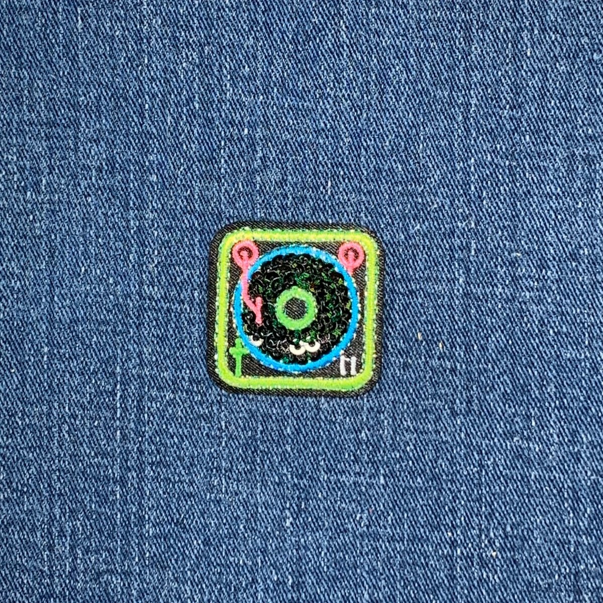 Colorful patch with a record player design on a denim background