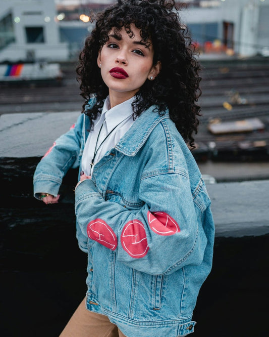 woman in blue denim jacket standing on sidewalk during daytime