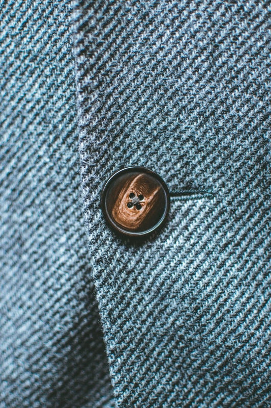silver round coin on blue textile