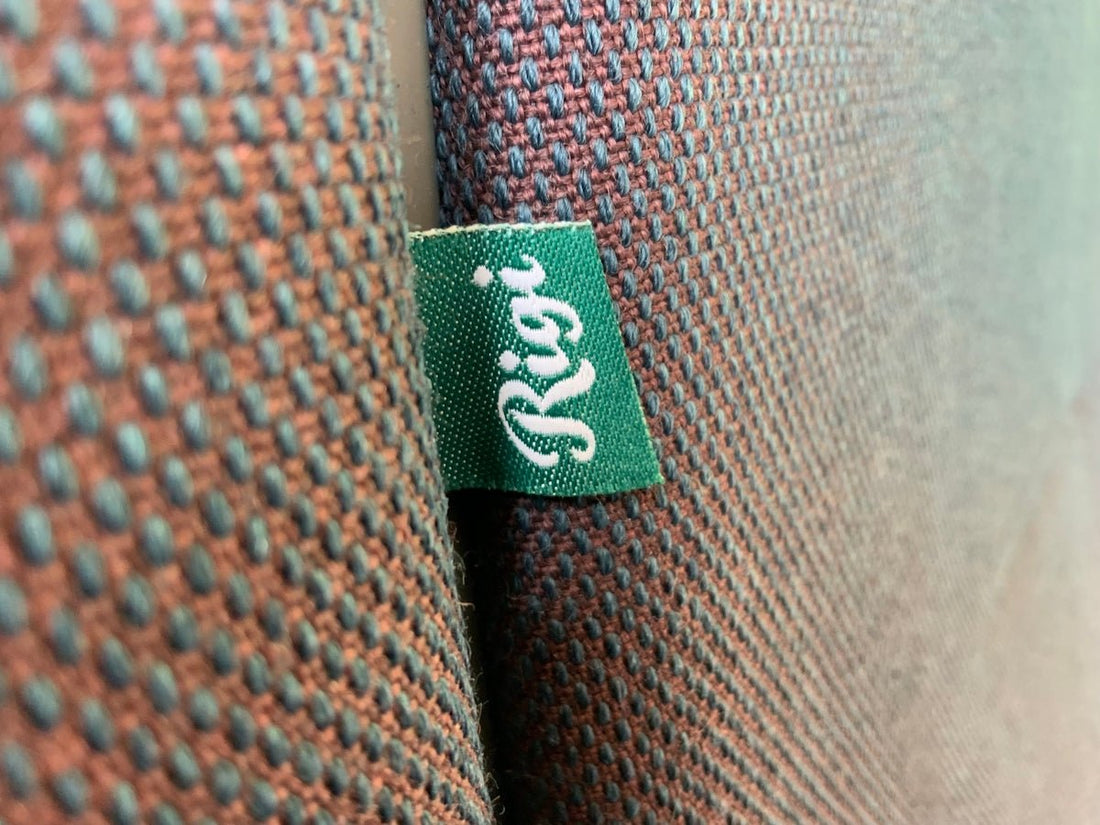 a green and black zipper on a brown leather jacket