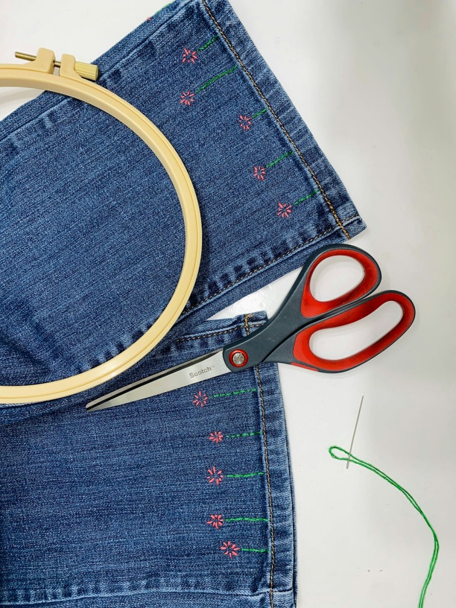 a pair of scissors sitting on top of a pair of jeans