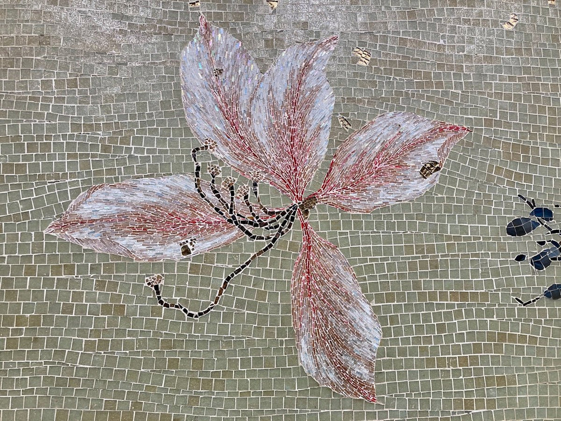 a painting of a flower on a tile wall