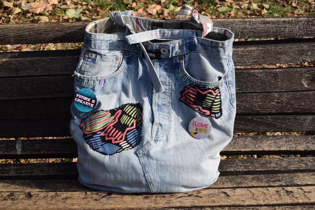 A denim bag sitting on top of a wooden bench