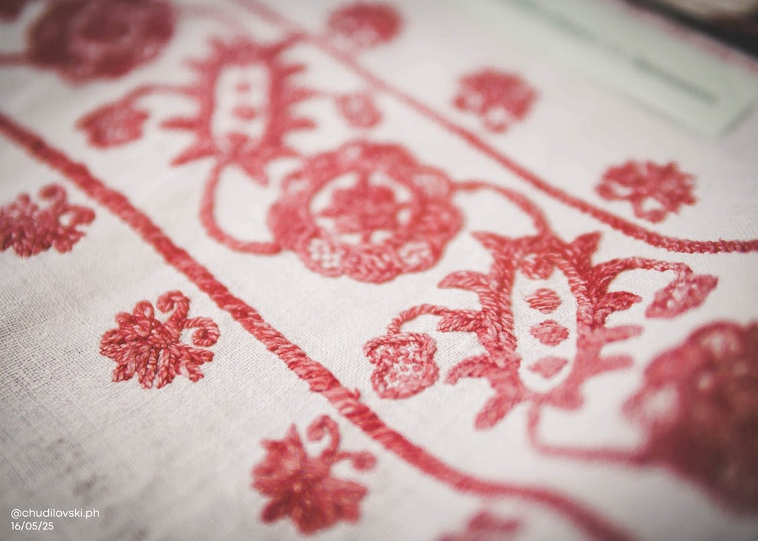 Red embroidered floral design on a white cloth.
