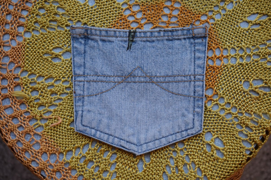 A denim pocket on a yellow knitted background