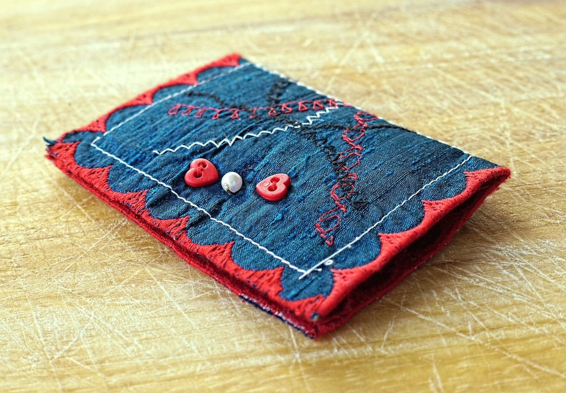 Handmade denim cardholder with red trim and buttons