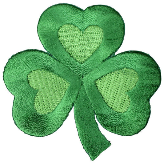 A green embroidered patch in the shape of a shamrock with heart shapes inside the leaves.