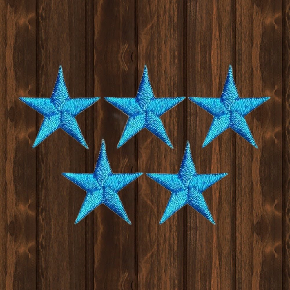 Five turquoise embroidered star patches, each 7/8 inches. Shown on a wood background.