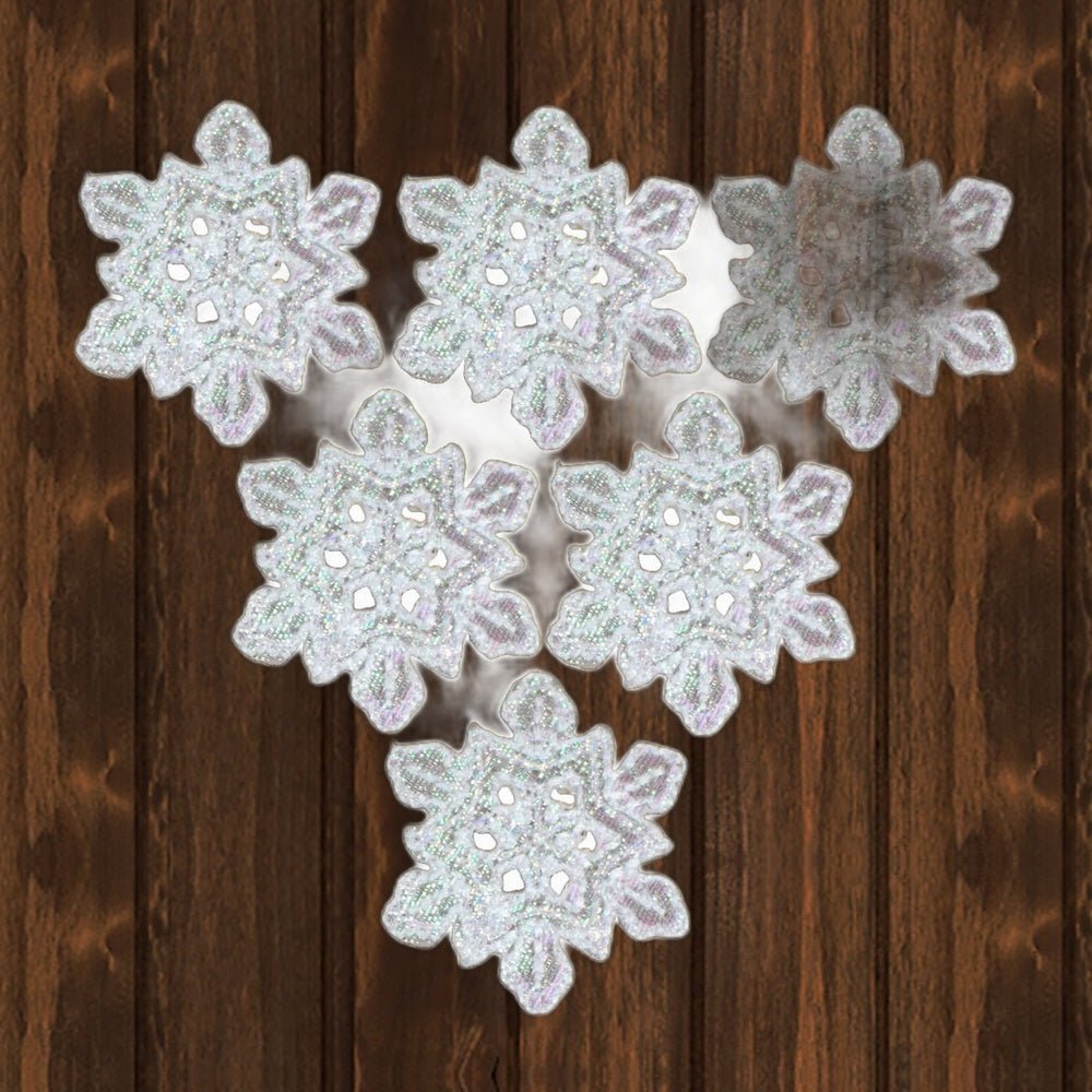 Six iridescent white snowflake patches, each 1.25 x 1 inches. Shown on a wood background.