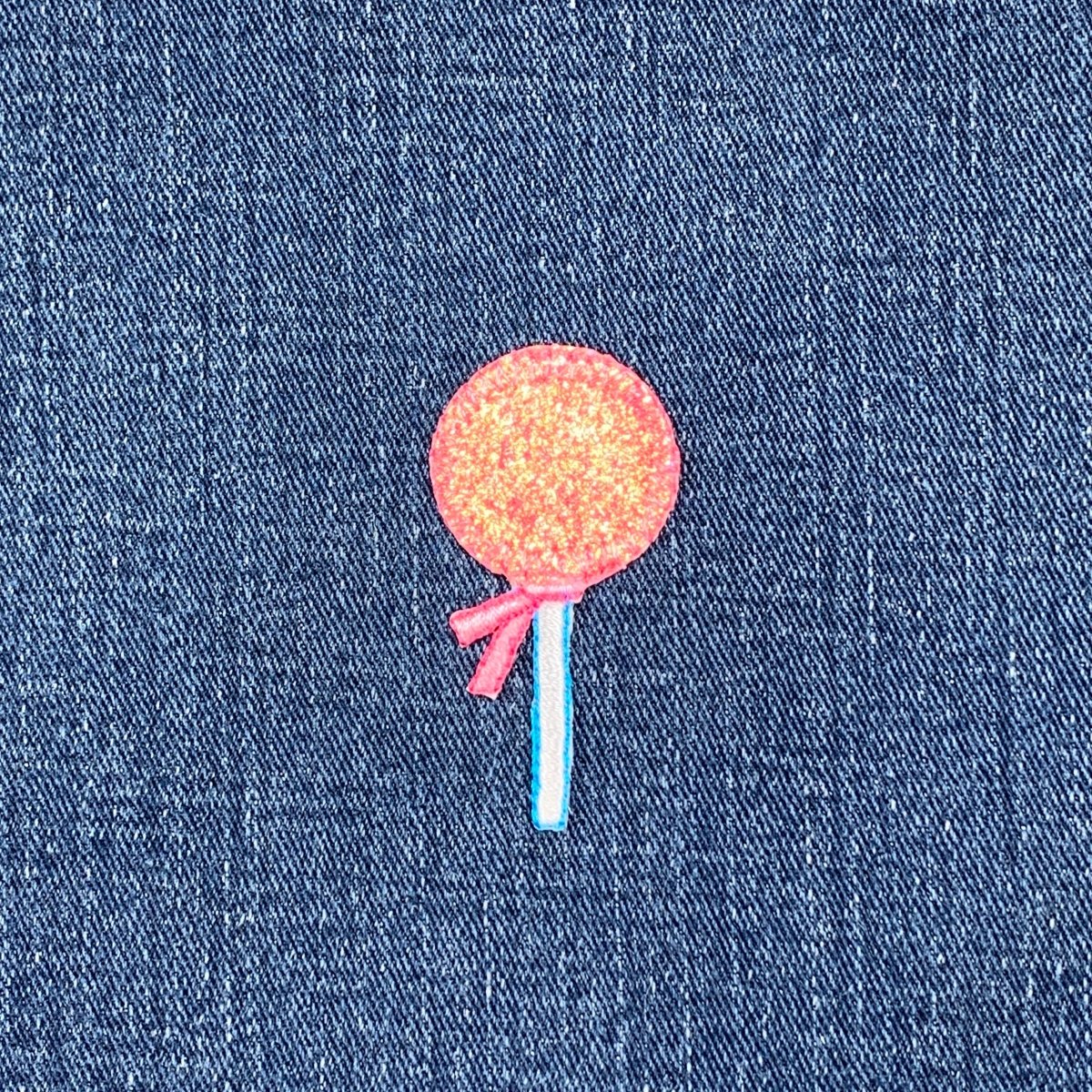 Pink lollipop patch on a denim background