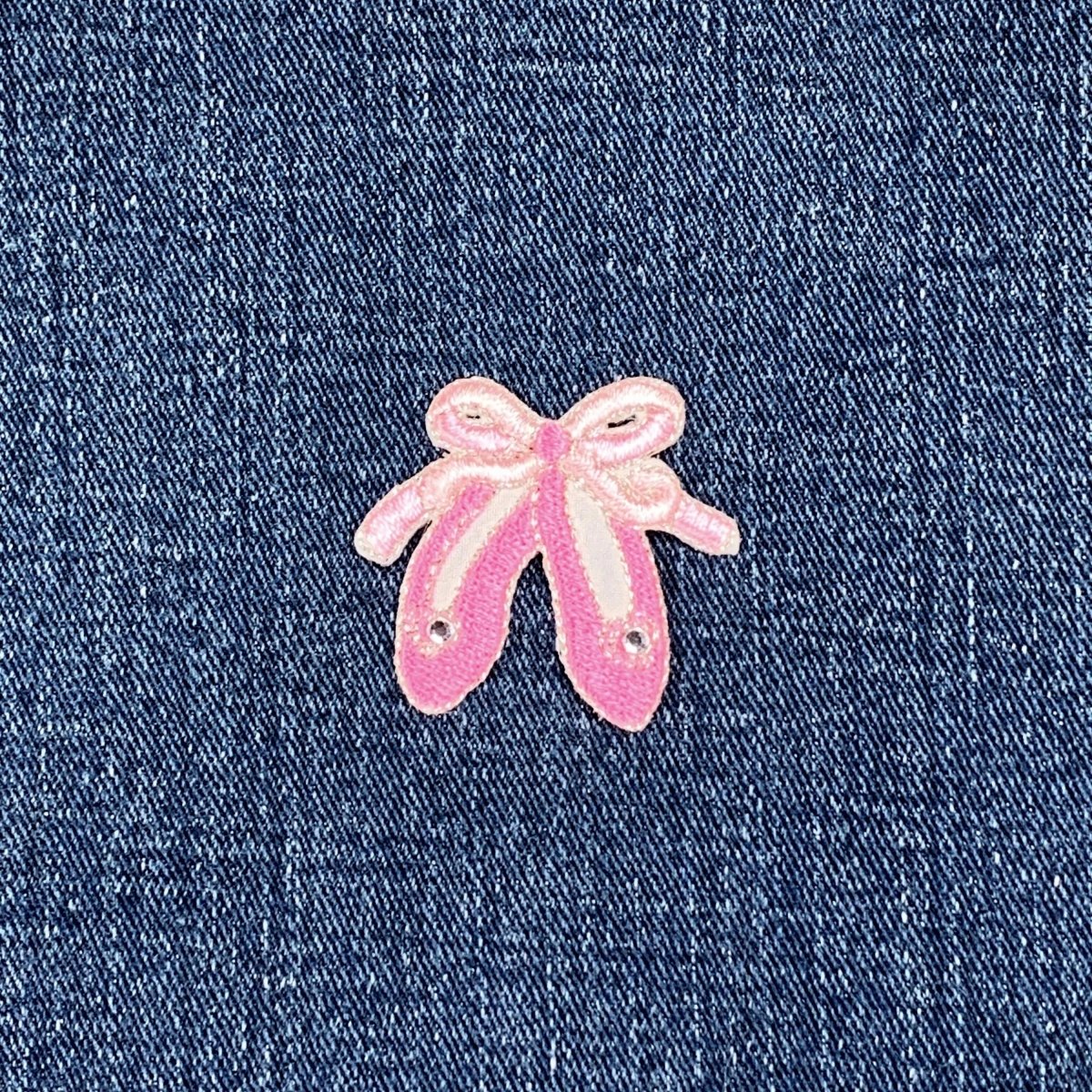 Pink ballet slippers patch on denim fabric