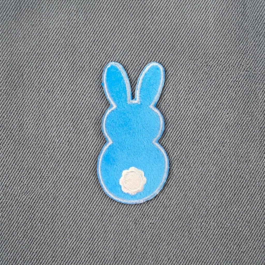 Blue bunny-shaped patch on denim fabric