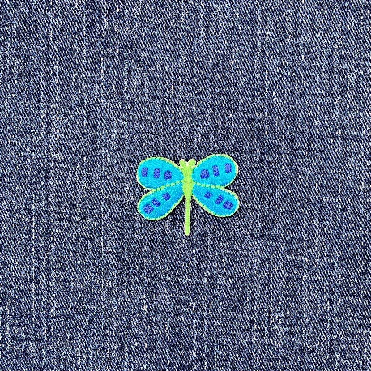 Blue and green dragonfly patch on denim fabric