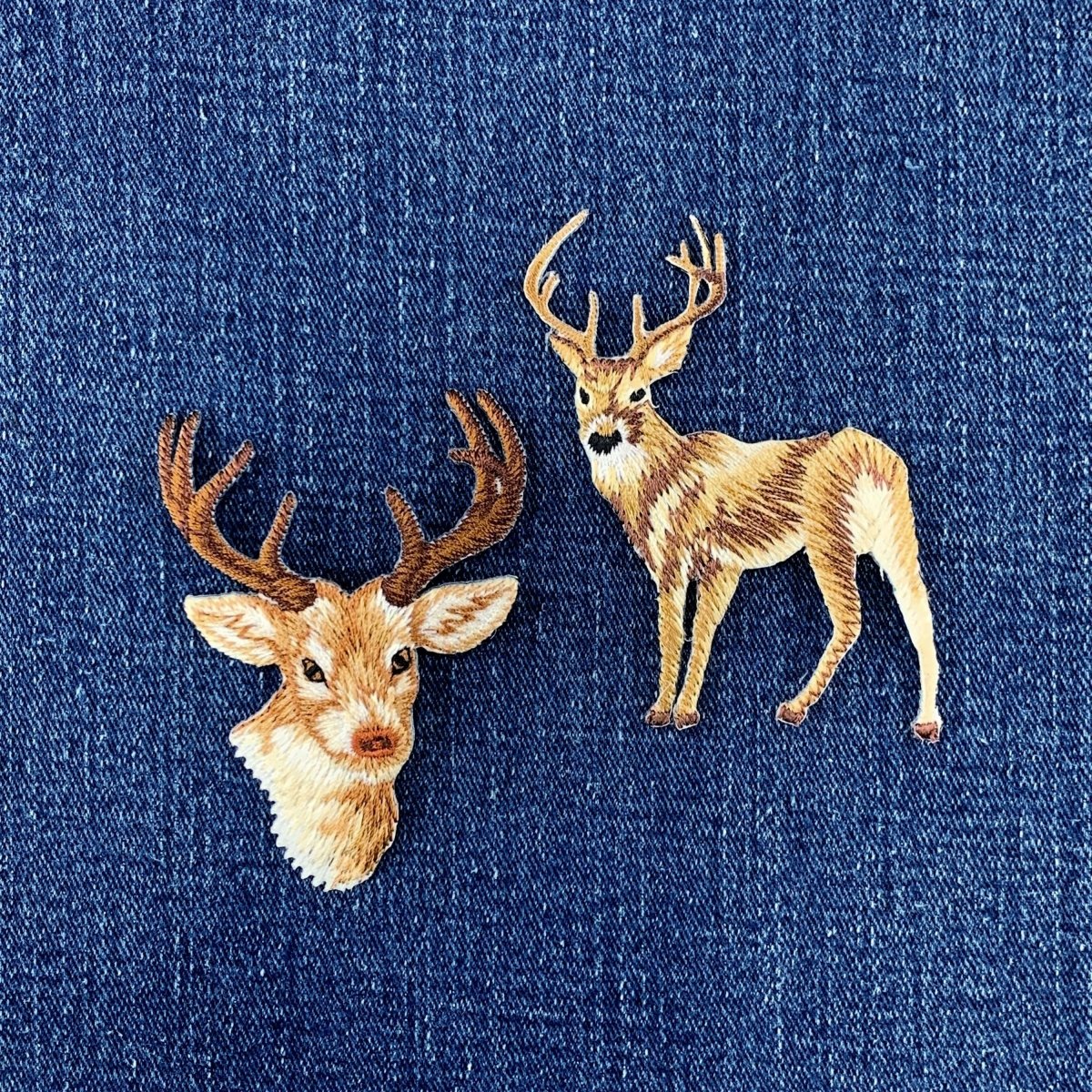 Embroidered deer patches on a blue denim fabric background