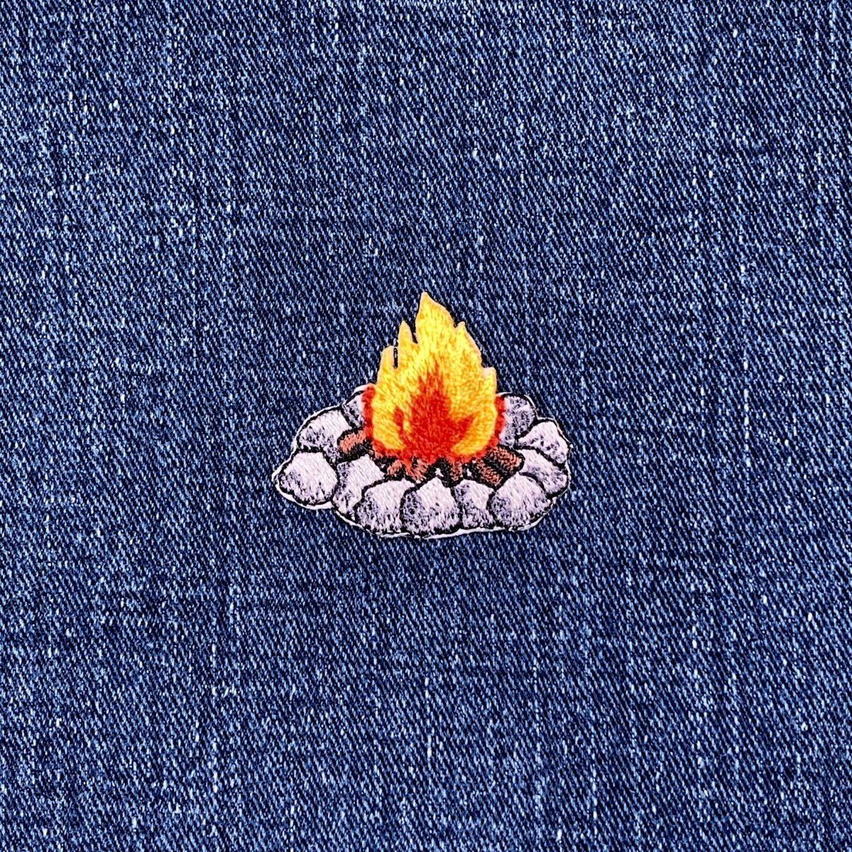 Embroidered campfire patch on denim fabric