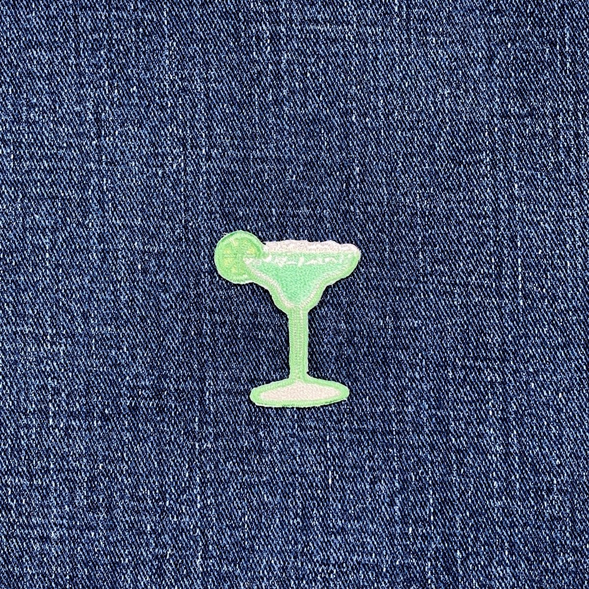 Green cocktail glass patch on blue denim fabric