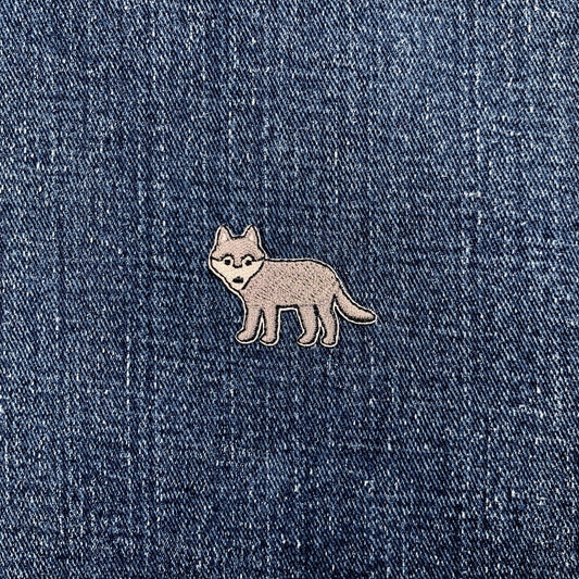 a mini wolf patch on a denim background