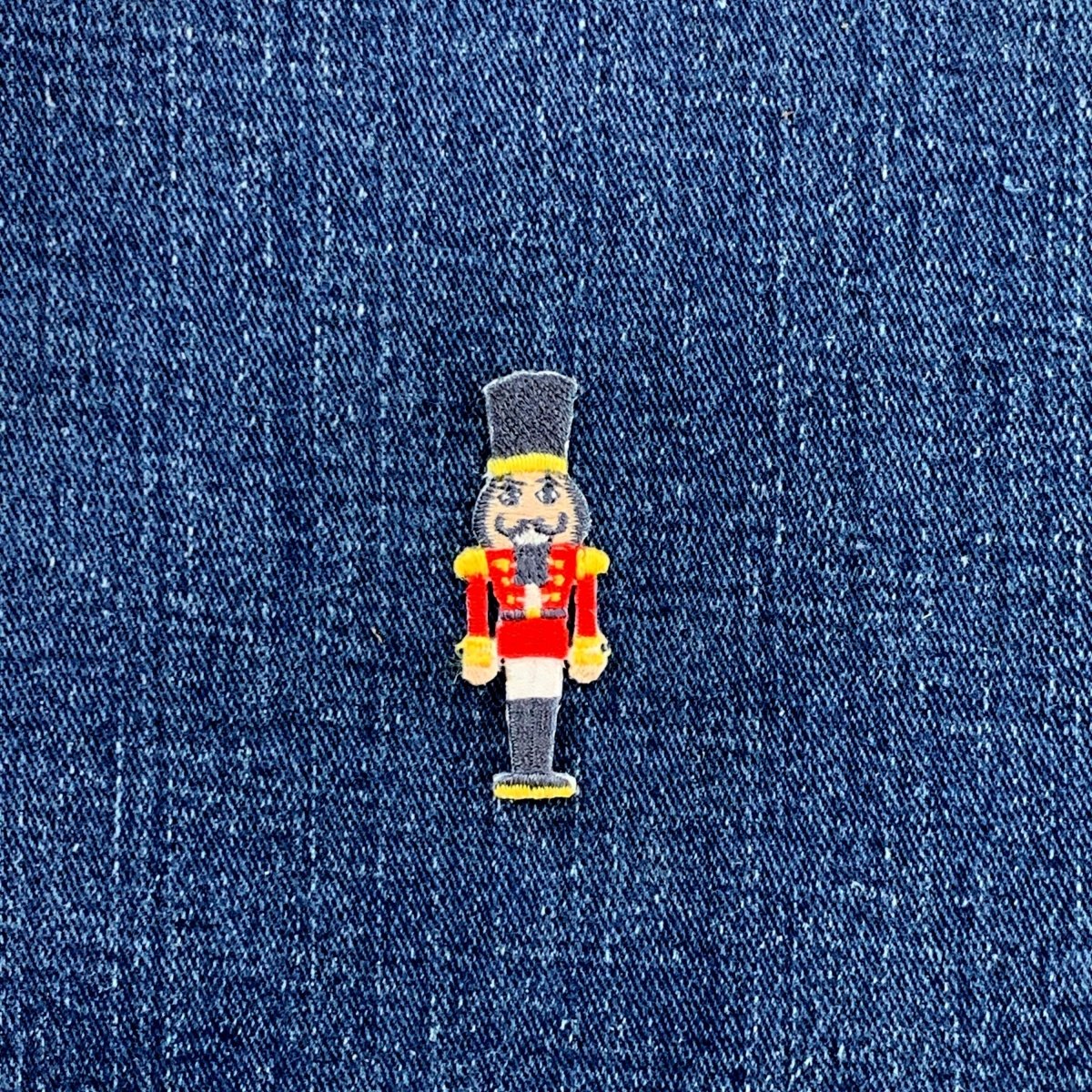 Embroidered nutcracker patch on denim fabric