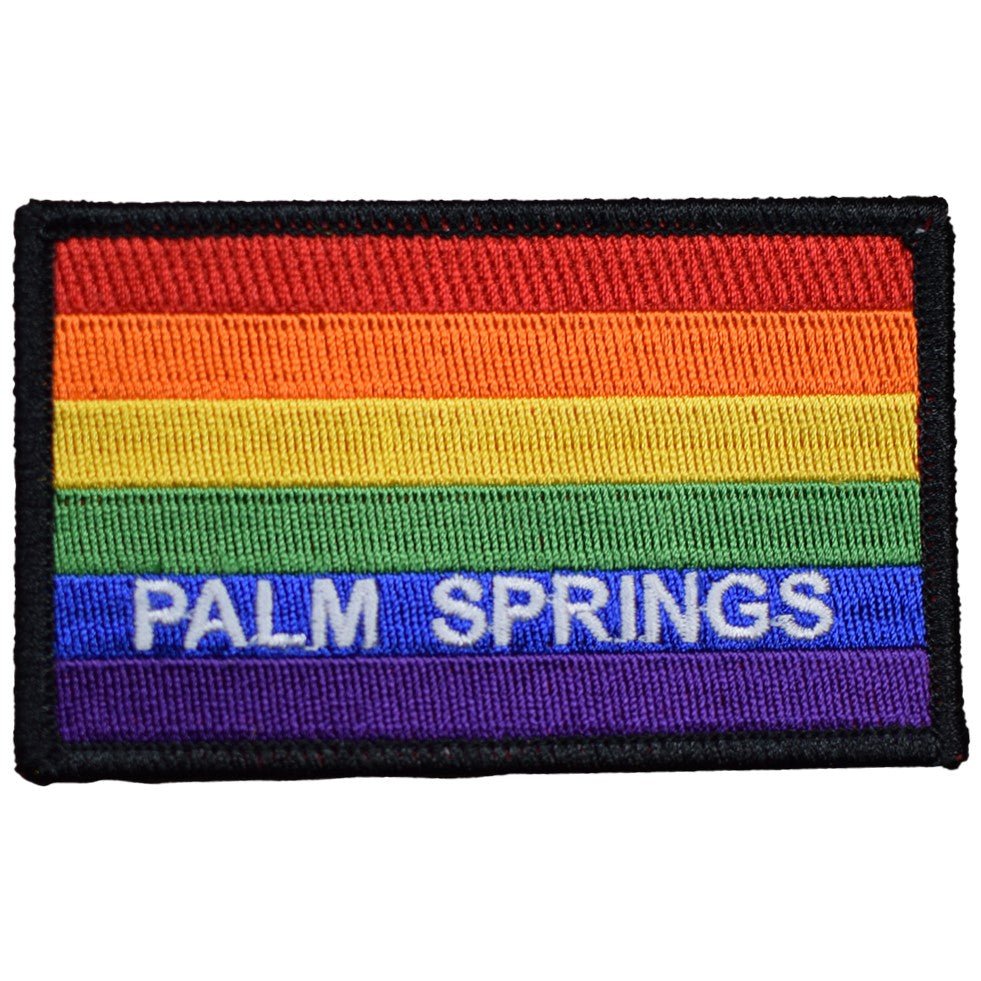 A rectangular, embroidered patch with a rainbow flag design and the text 'Palm Springs' across the center in white letters, bordered with a black line.