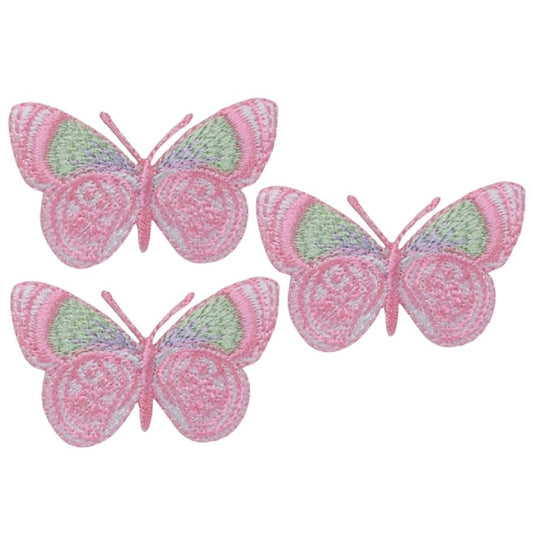 Three embroidered butterfly patches with wings primarily colored in shades of pink, pale green, and lavender, arranged in a small triangular cluster.