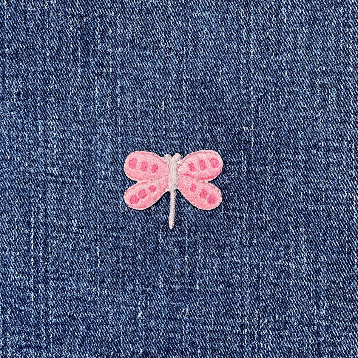Pink dragonfly patch on blue denim fabric