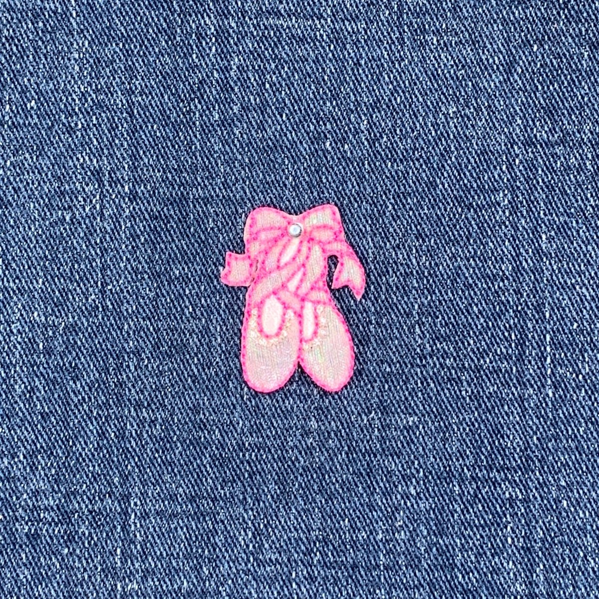 Pink embroidered ballet slipper patch on denim fabric