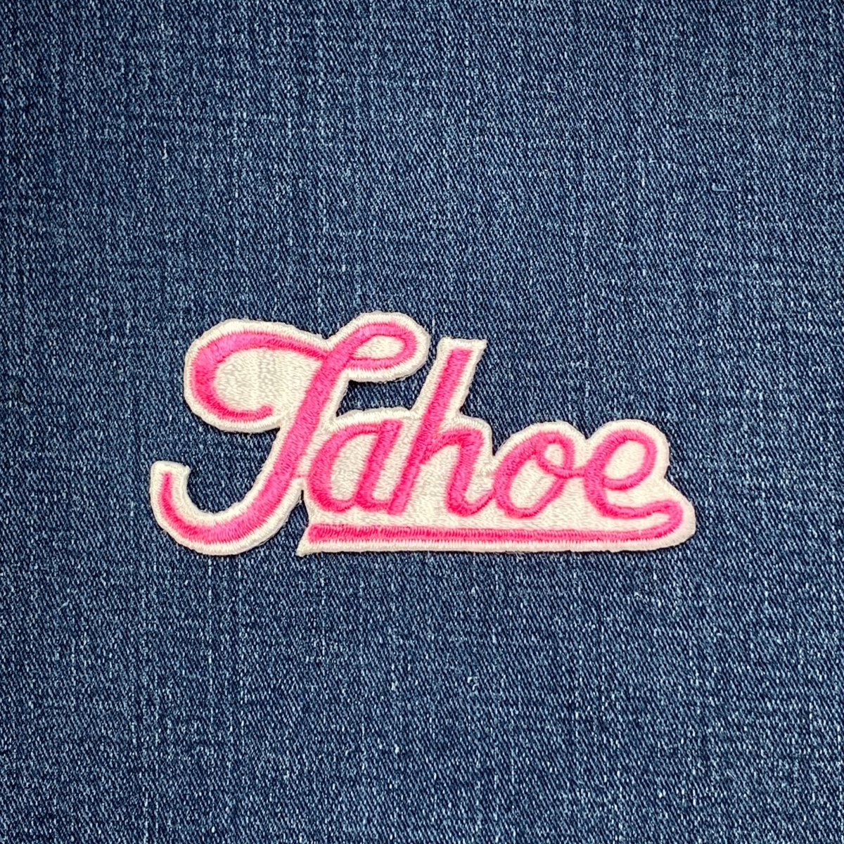 Pink 'Tahoe' patch on denim fabric