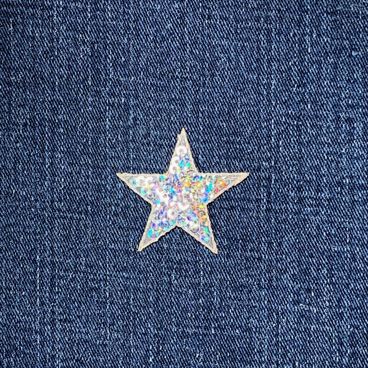 Star-shaped silver sequin patch on a denim fabric background