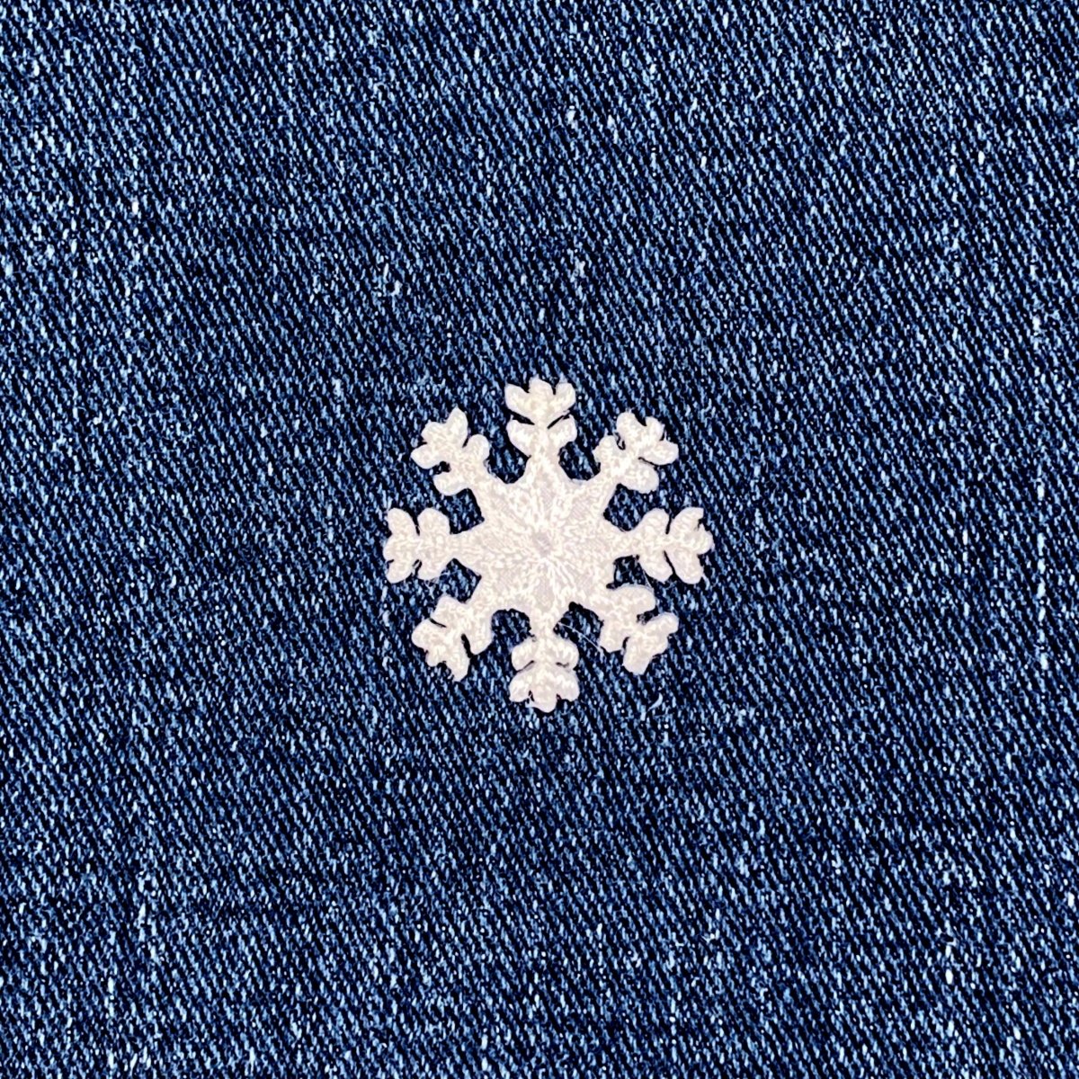White snowflake patch on a blue denim background